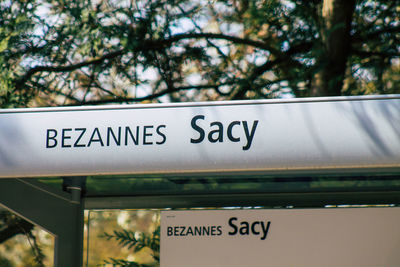 Low angle view of information sign against trees