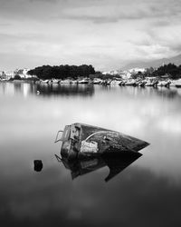 Sailboats moored on lake against sky