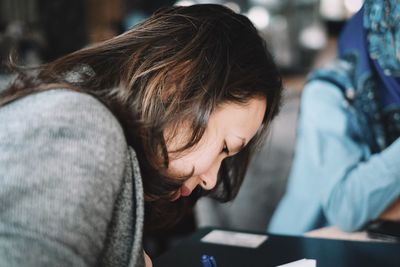 Close-up of young woman writing