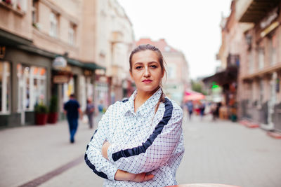 Portrait of woman standing on street in city