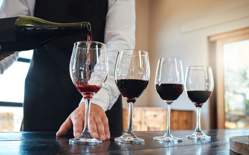 Midsection of man holding wineglass