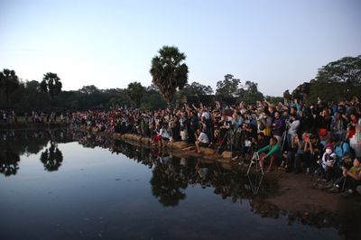 Group of people in lake against clear sky