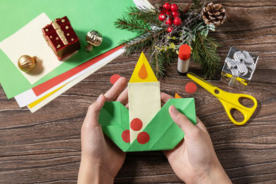 High angle view of man holding christmas decorations on table