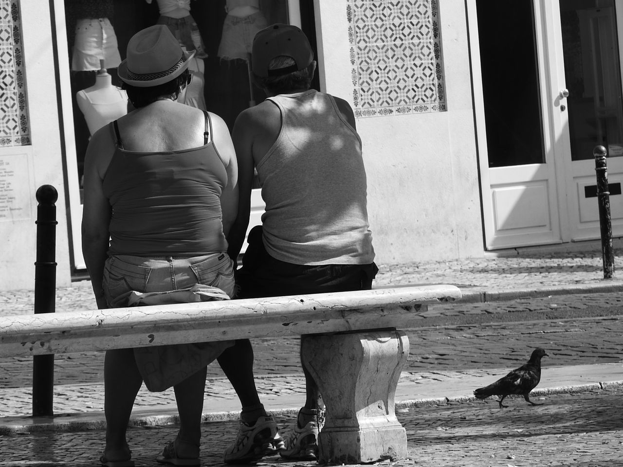 REAR VIEW OF MEN ON FLOOR IN FRONT OF BUILDING