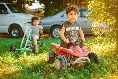 Portrait of boy sitting at toy car