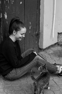 Young woman with dog sitting by door