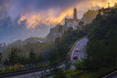 High angle view of road amidst trees against sky