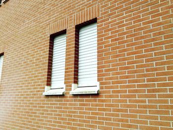 Low angle view of window on brick wall of building