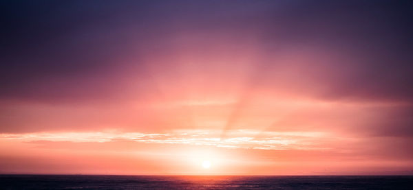 Scenic view of sea against romantic sky at sunset