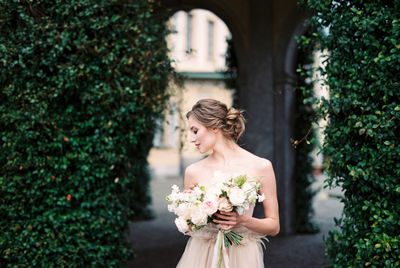 Young woman standing by plants