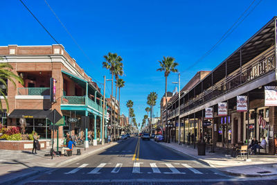 Street amidst buildings against blue sky