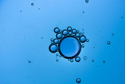 Full frame shot of water drops on blue background