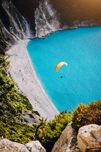 High angle view of person paragliding over beach