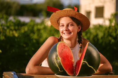 Happy smiling girl with half red fresh watermelon enjoying summer life outdoors. summer lifestyle