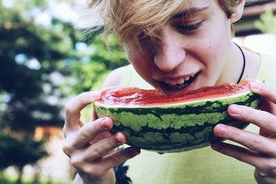 Close-up of teenage boy eating watermelon