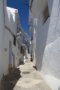 Alley amidst houses against clear sky