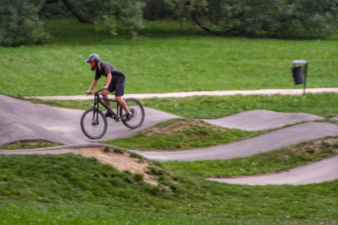 MAN RIDING BICYCLE ON FIELD