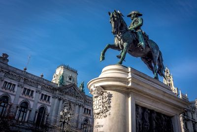 Low angle view of statue against blue sky