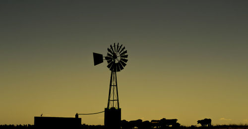 Silhouette of windmill against clear sky during sunset