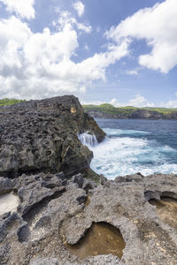 Scenic view of rocks on beach against sky