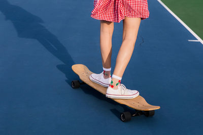 Low section of woman standing on skateboard