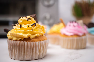 Delicious homemade cupcakes with colorful cream and topping with candy