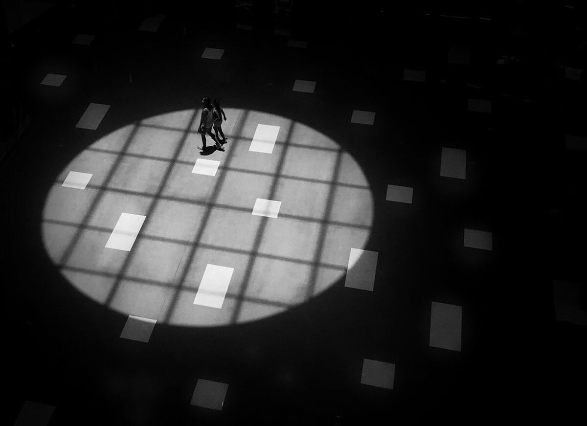 HIGH ANGLE VIEW OF WOMAN WALKING IN CORRIDOR