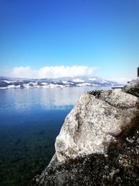 Scenic view of rock on sea against sky