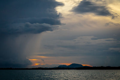 Scenic view of sea against dramatic sky during sunset