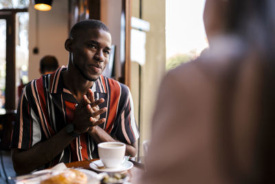 Smiling young man with girlfriend in coffee shop