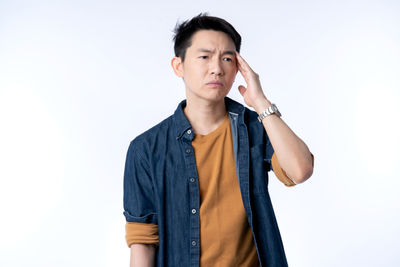 Young man looking away against white background