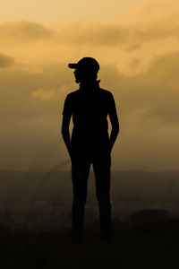 Silhouette man standing against orange sky