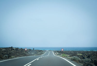 Road amidst landscape against clear blue sky