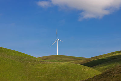 Wind power mill on the green hills, clean energy