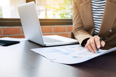 Close-up of man using laptop on table