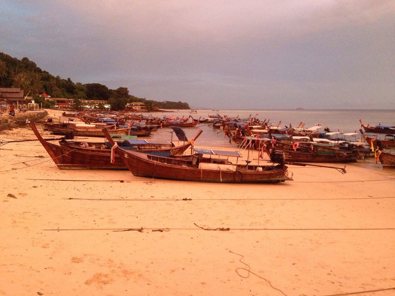 nautical vessel, boat, sea, moored, transportation, water, mode of transport, beach, sky, shore, sand, horizon over water, building exterior, harbor, built structure, incidental people, nature, outdoors, day, travel