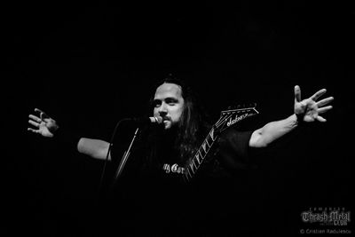Full length of young man holding hands over black background
