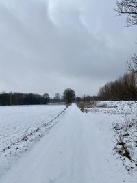 Snow covered field against sky
