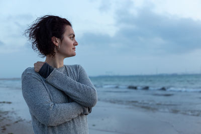 Portrait of a beautiful woman on the beach looking at the sea