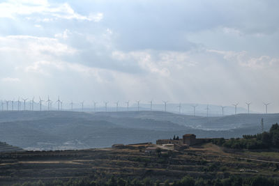 Scenic view of field against sky. wind mills on the horizon