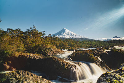 Scenic view of waterfall against mountain