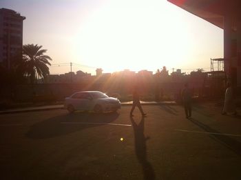 Cars on road against sky during sunset