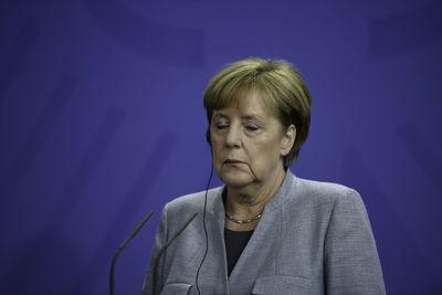 Portrait of woman against blue background