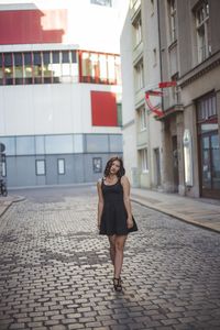 Full length of woman walking on street in city