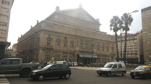 Cars on street amidst buildings in city