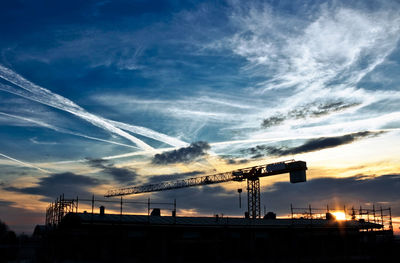 Low angle view of crane against sky during sunset