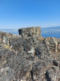 Rock formations on land against clear blue sky