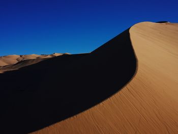 Scenic view of desert against clear blue sky