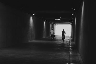 Rear view of man walking in tunnel