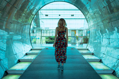 Rear view of woman standing in corridor